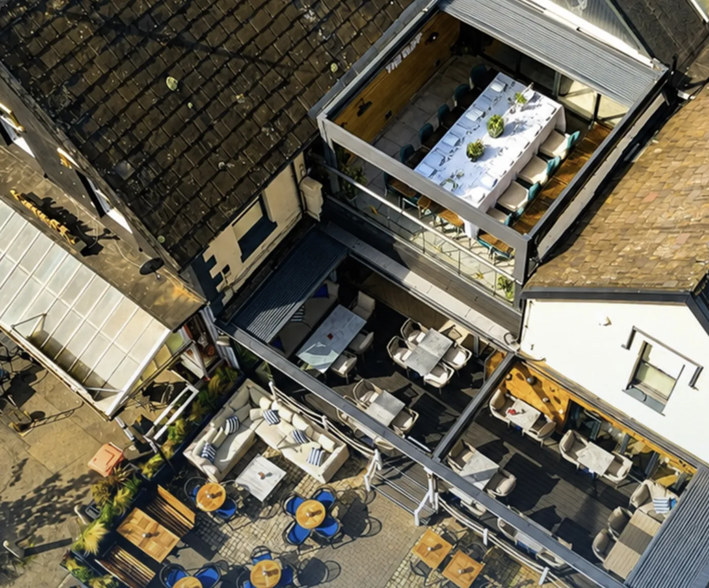 The Cliff from above: a long table laid on the rooftop terrace over Coast and its courtyard