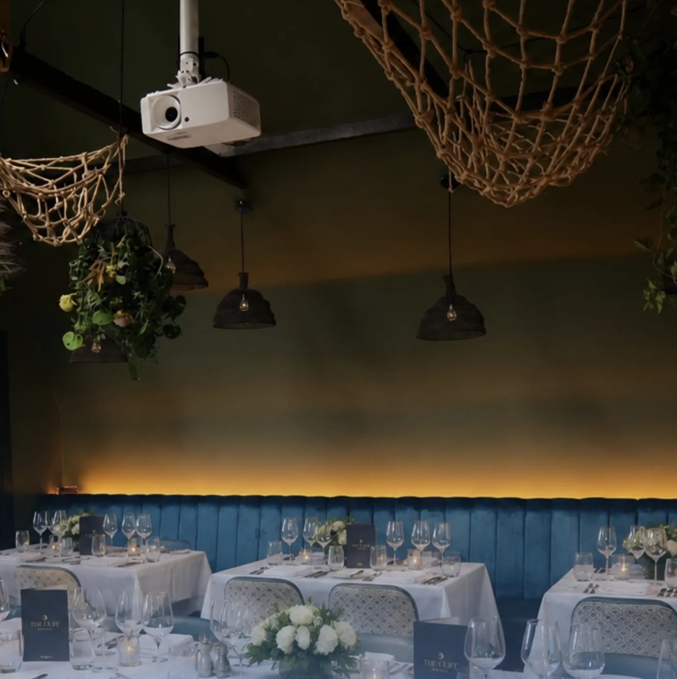 Tables laid for private dining in front of the velvet banquette